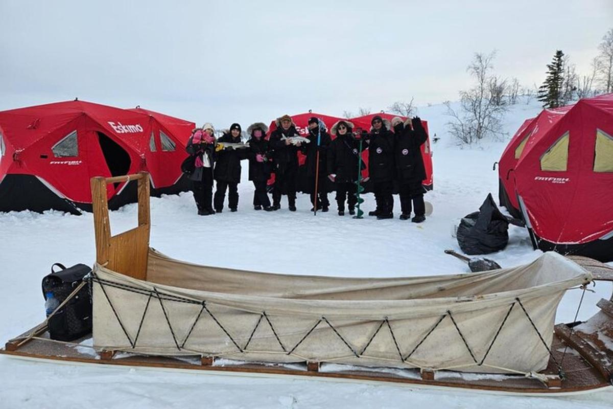 a group of people standing in front of tents in the snow