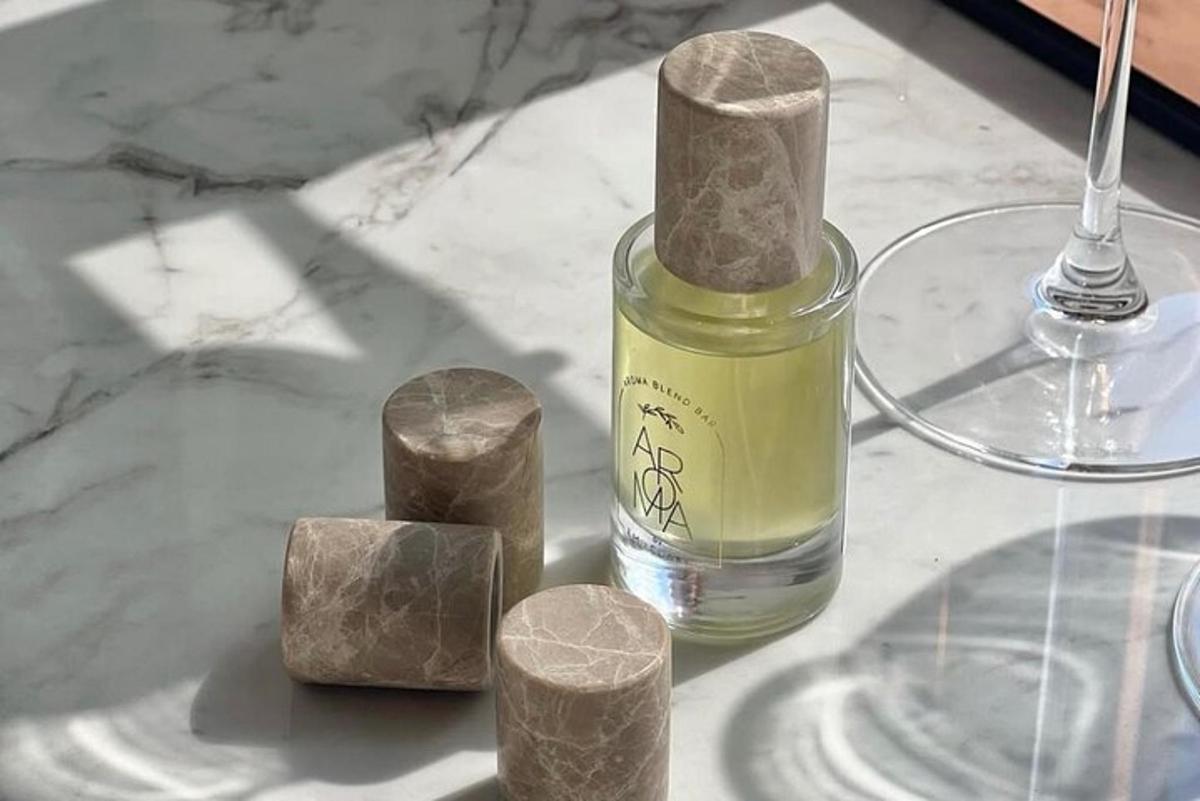 una ampolla de perfum sobre una taula amb pedres