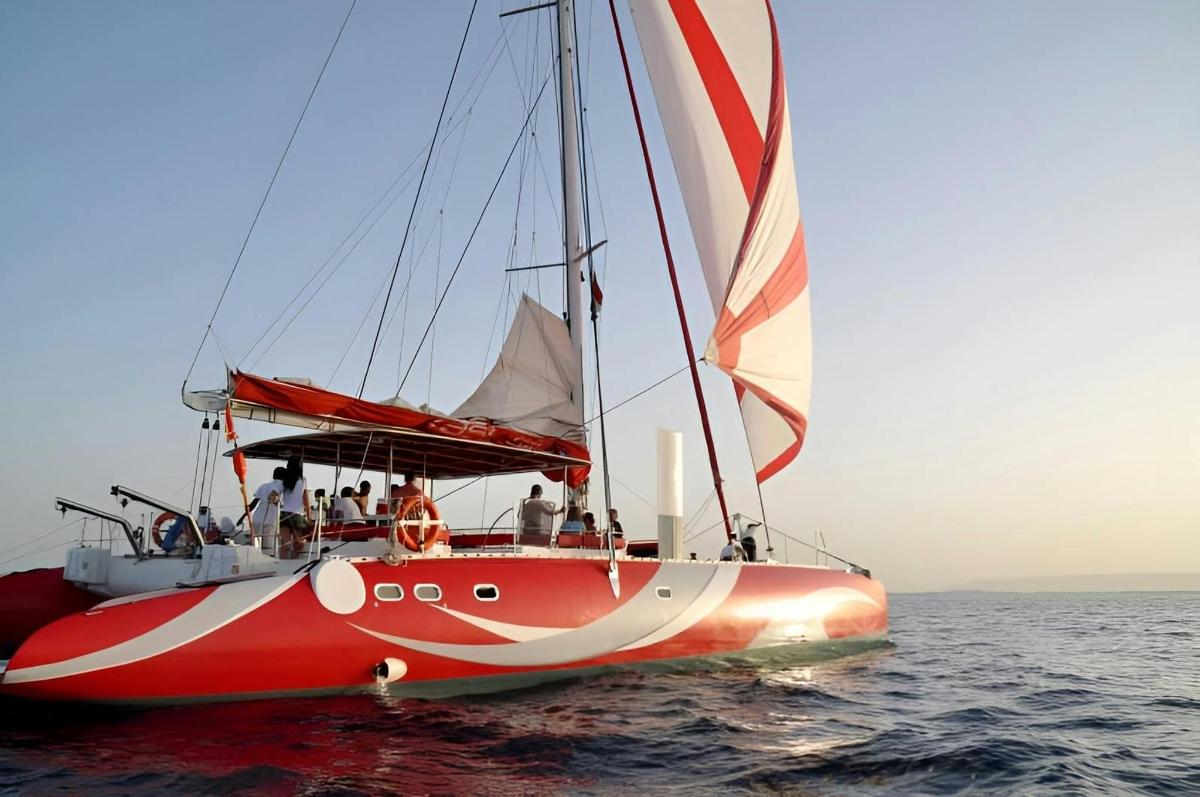 a red boat in the water with people on it