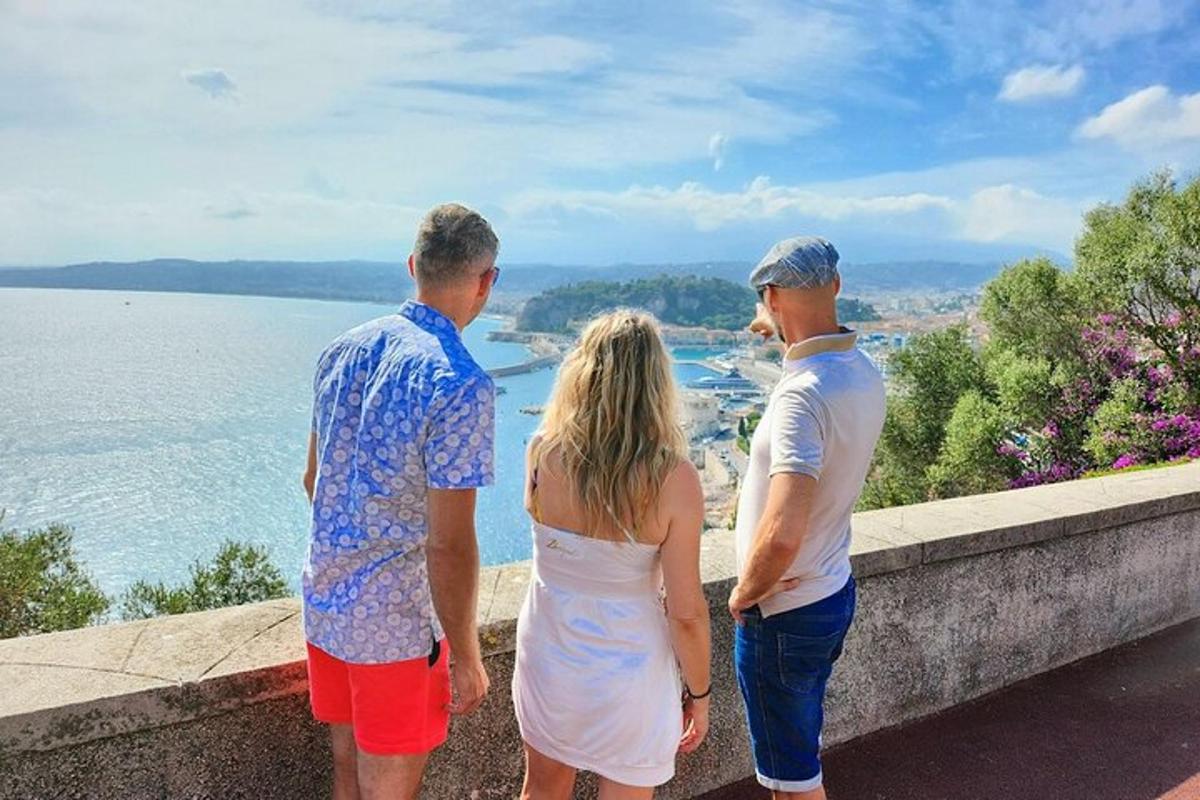 Tres personas paradas en una cornisa mirando el agua