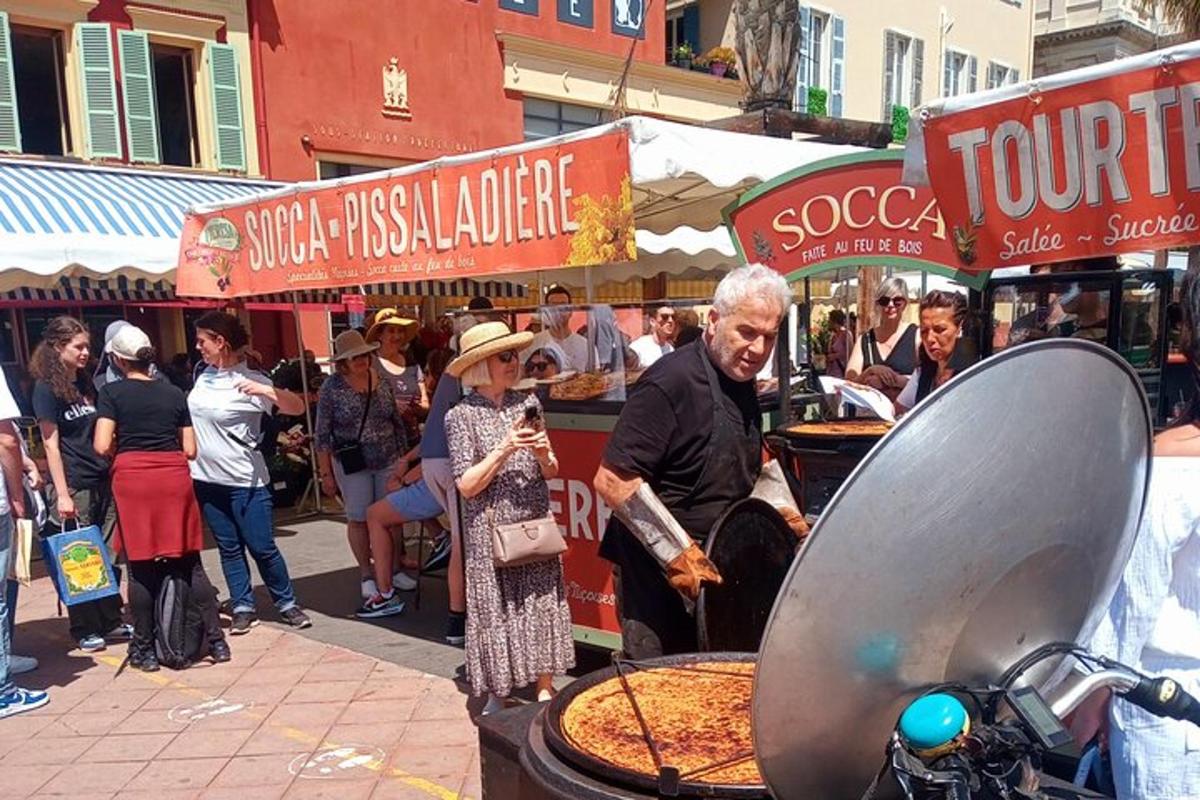 un gruppo di persone in piedi attorno a una bancarella di pizza
