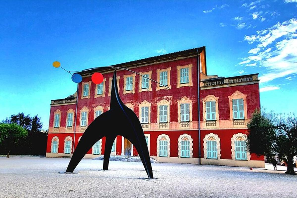 un grande edificio rosso con una statua di fronte