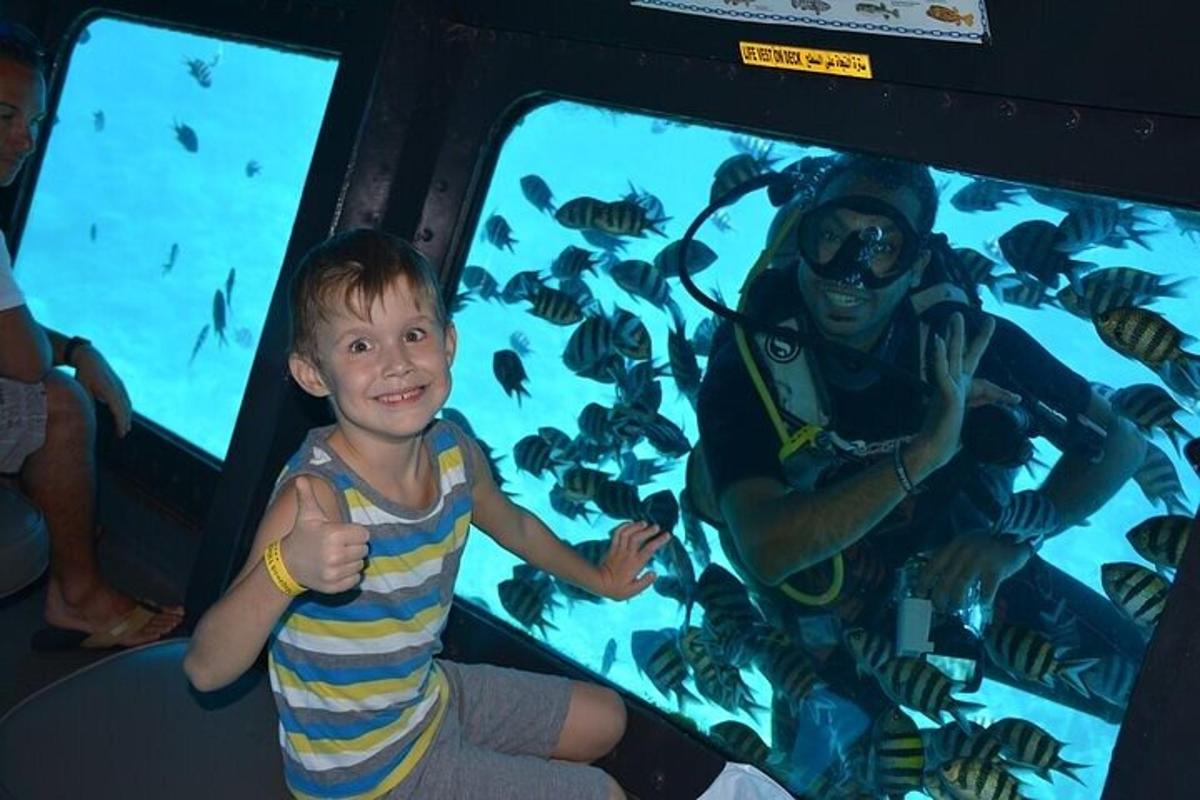ein kleiner Junge sitzt vor einem Aquarium