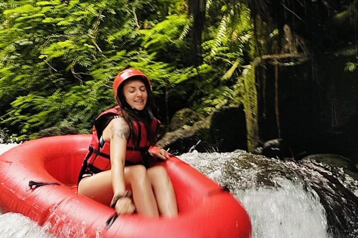 seorang gadis sedang duduk di rakit merah di sungai