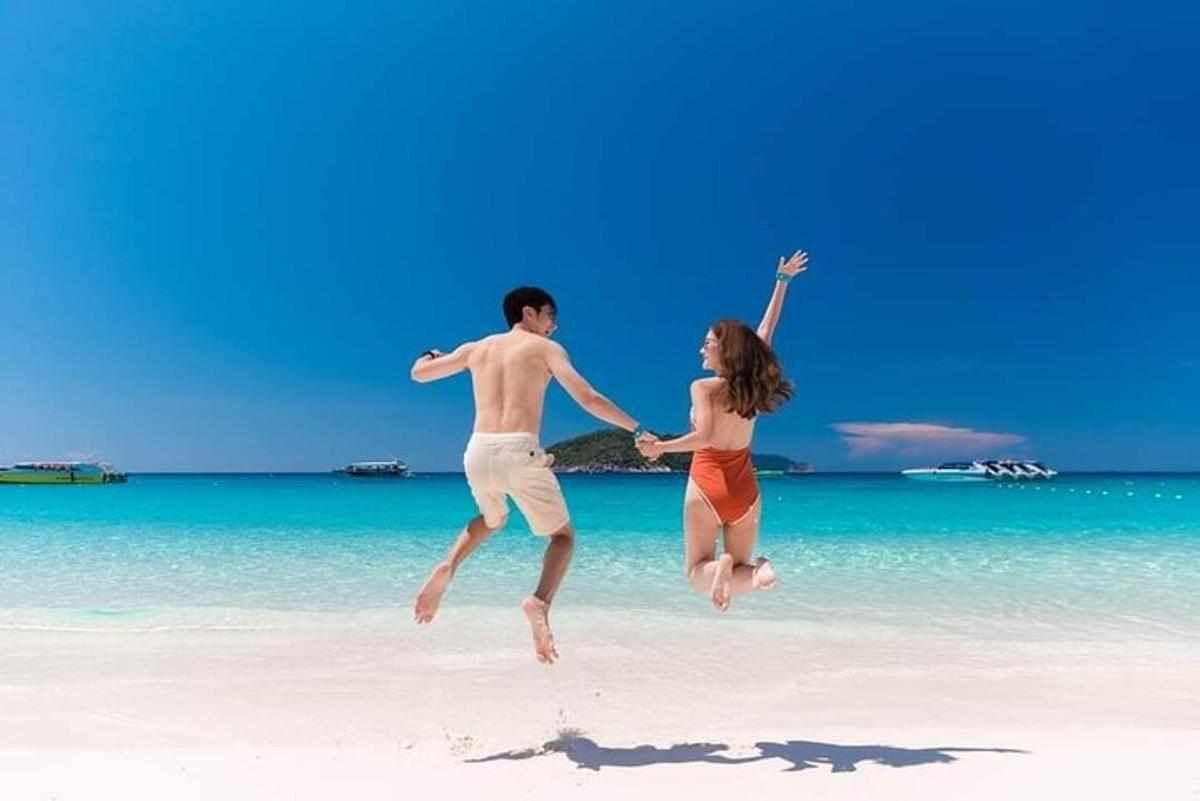 a man and a woman jumping on a beach