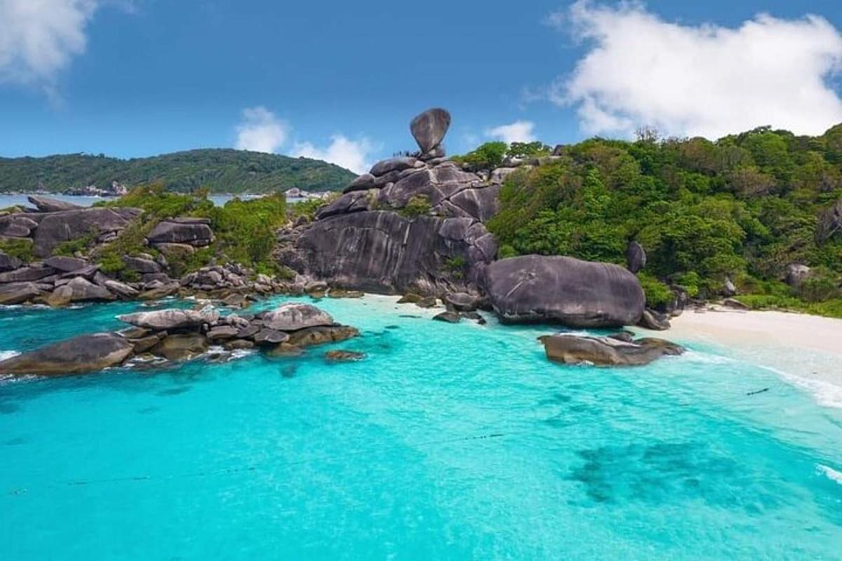 an island with rocks and blue water and a beach