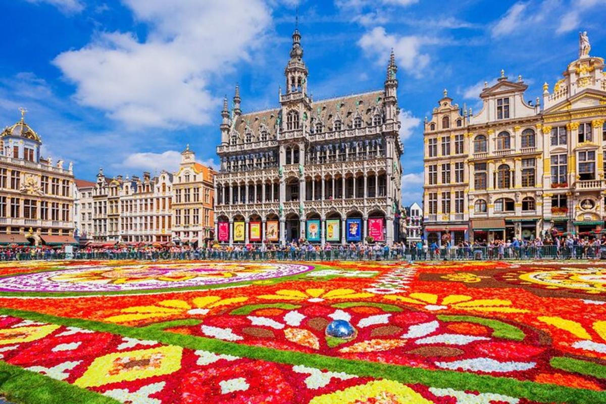 Un gran edificio con un laberinto de flores delante.
