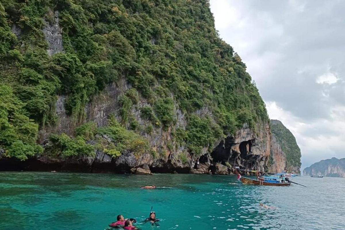 isang grupo ng mga tao sa tubig malapit sa isang bundok