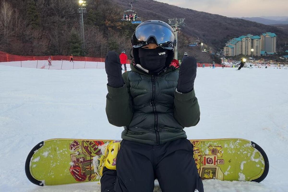 a person standing in the snow with a snowboard