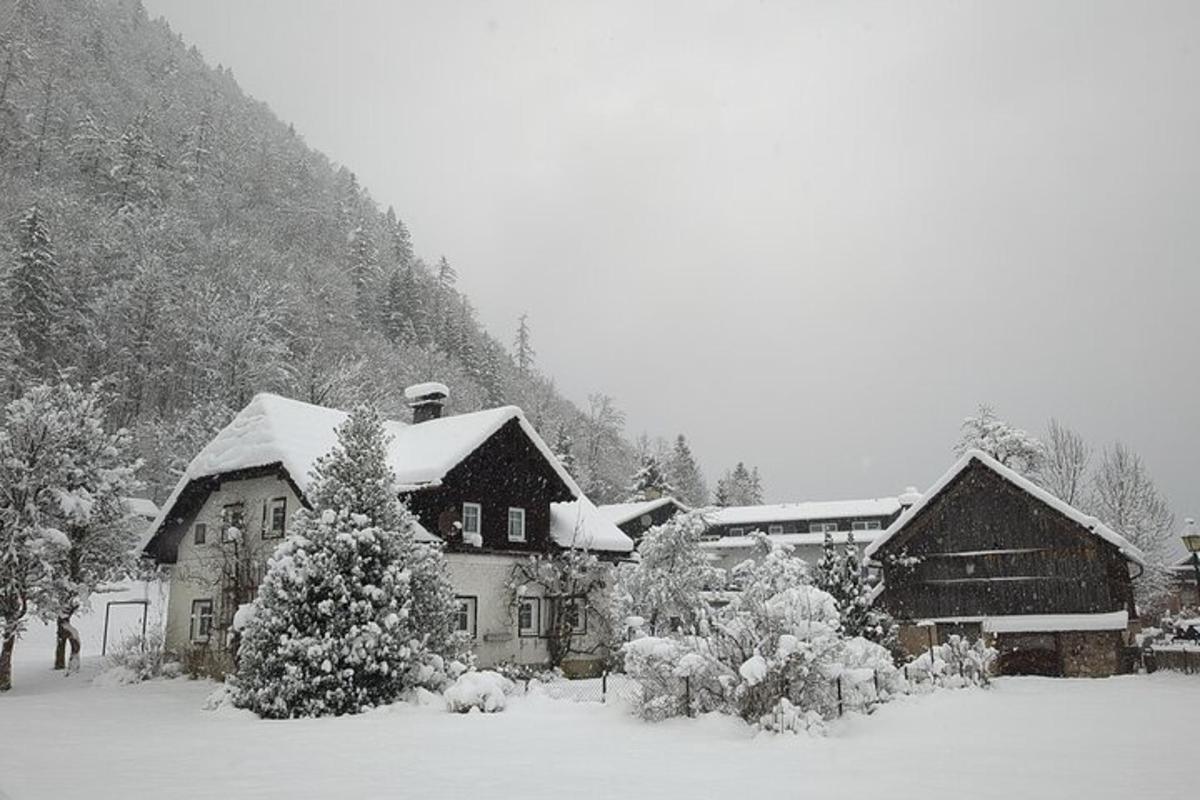 et hus dekket av snø foran et fjell