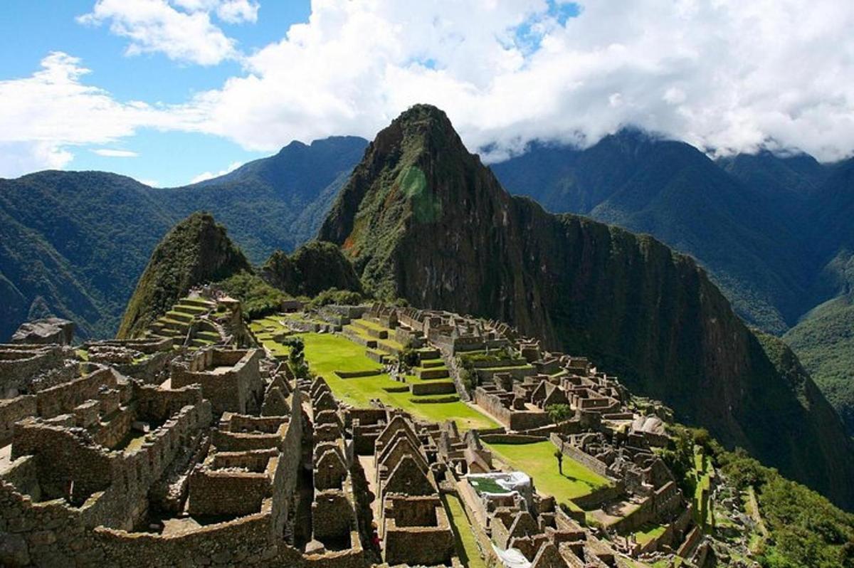 Una ciudad antigua en una montaña con montañas al fondo
