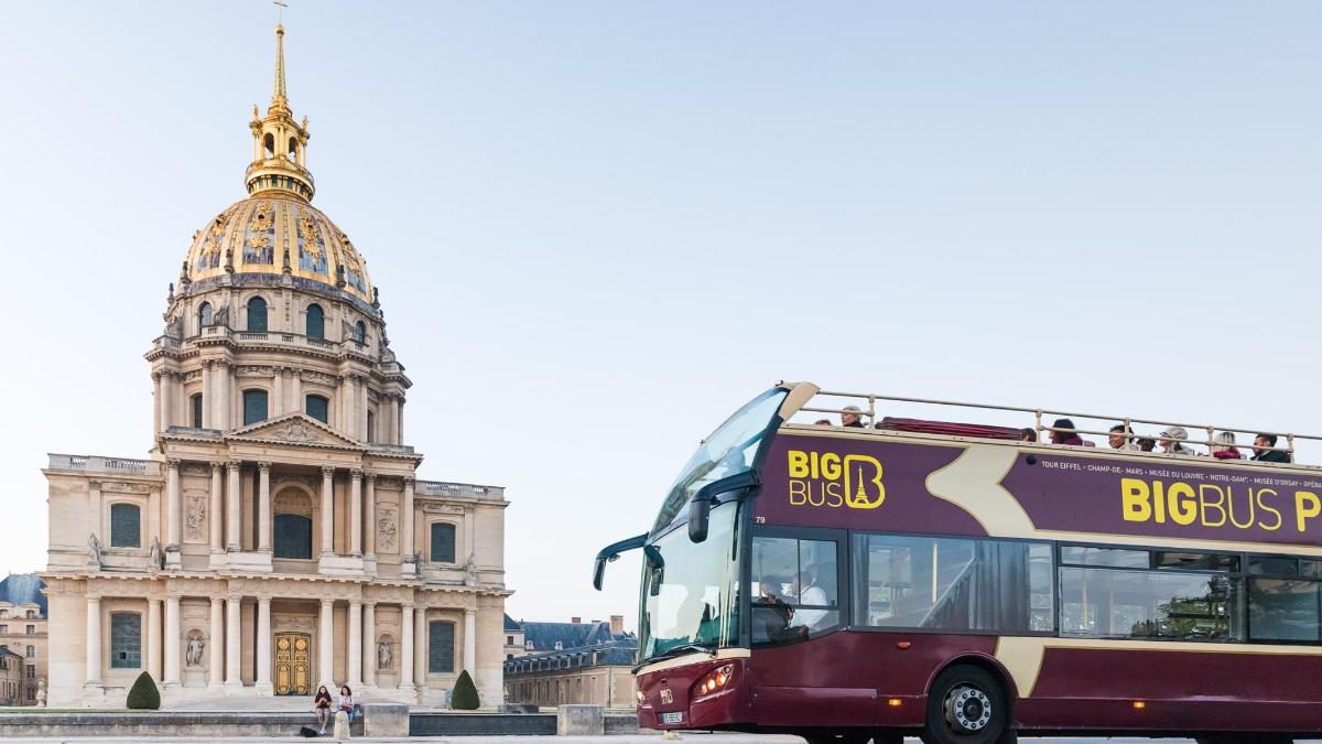 um ônibus está estacionado em frente a um prédio