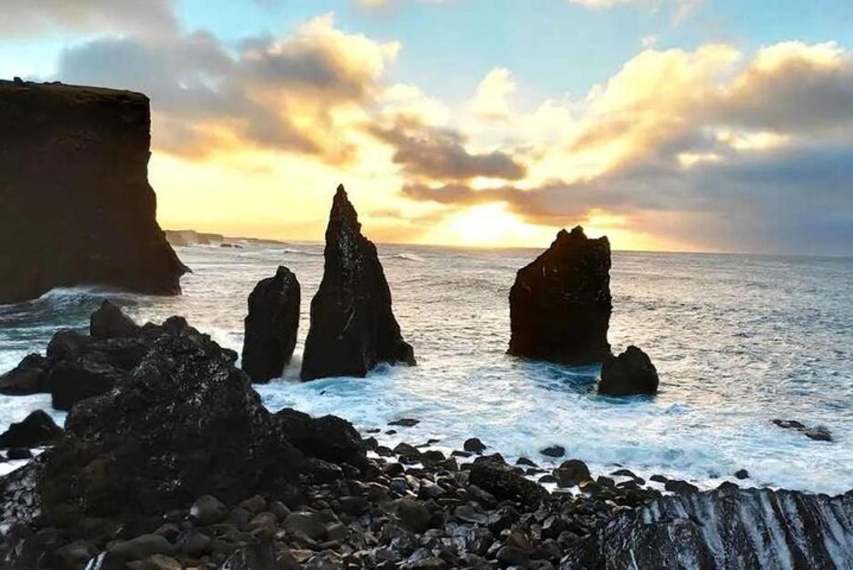 en gruppe steiner i havet ved solnedgang