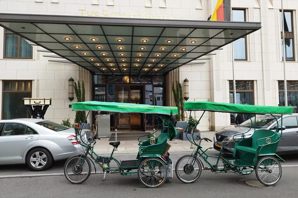 Dos rickshaws verdes estacionados frente a un edificio