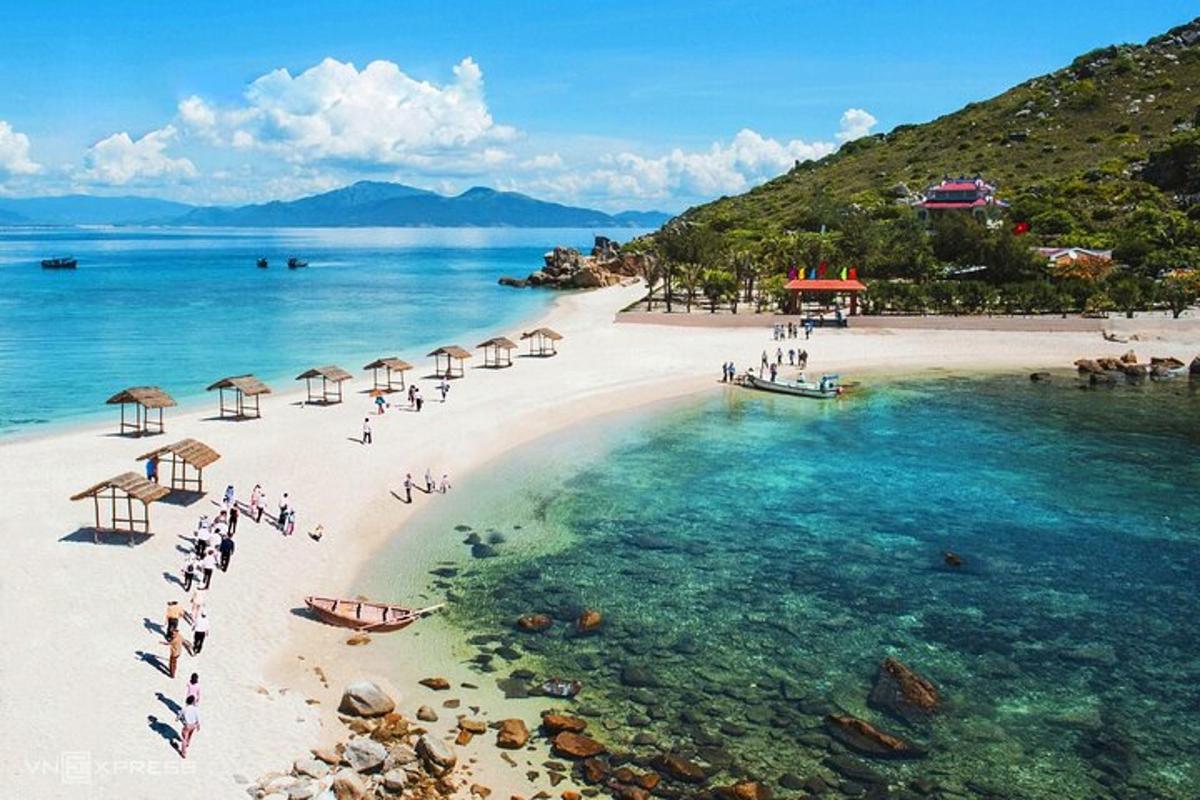 una playa con sombrillas y gente en el agua