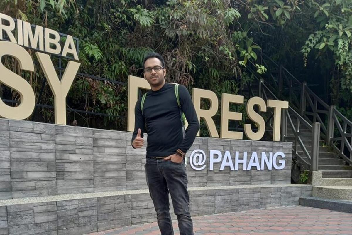 a man with a backpack standing in front of a sign