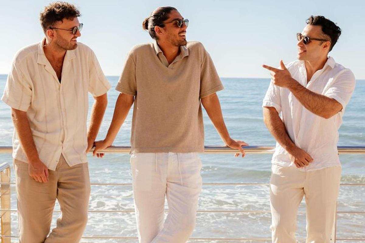 un gruppo di tre uomini in piedi sulla spiaggia