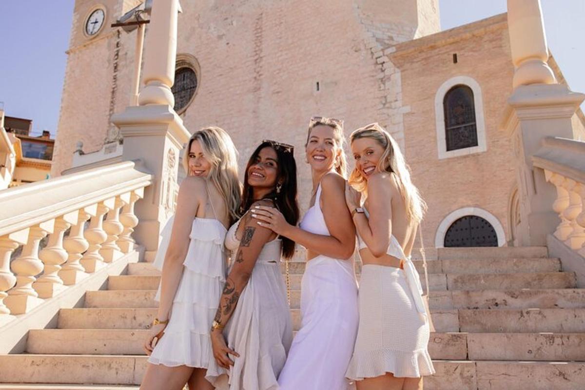 tre ragazze in abiti bianchi in posa davanti a un edificio