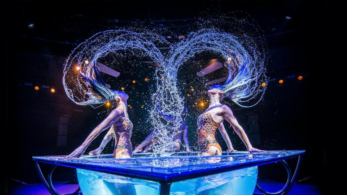 Dos estatuas de mujeres en una fuente con agua
