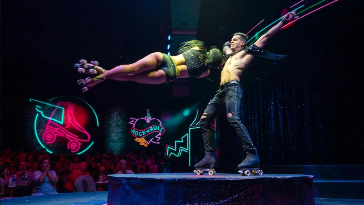Un hombre y una mujer en patinetas en un escenario.