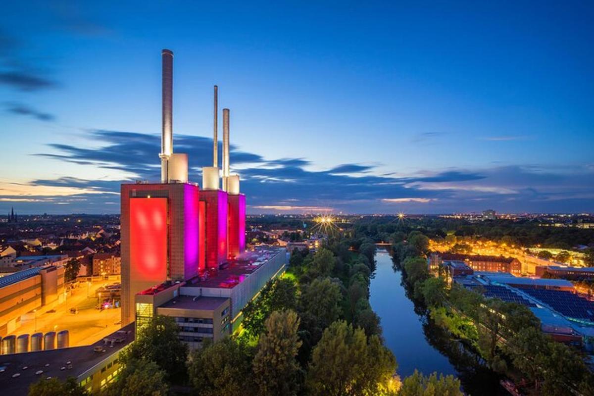 a building with red lights on the side of a river