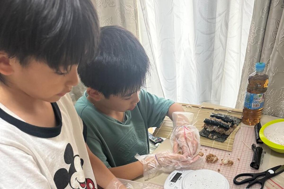 dua budak lelaki duduk di meja sambil melihat sesuatu