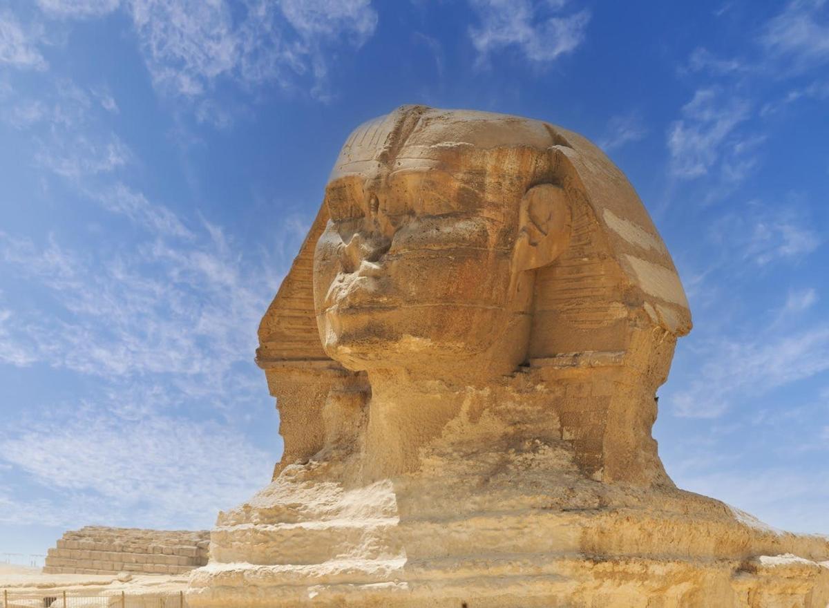 una gran estàtua de pedra d'Anubis en un dia assolellat