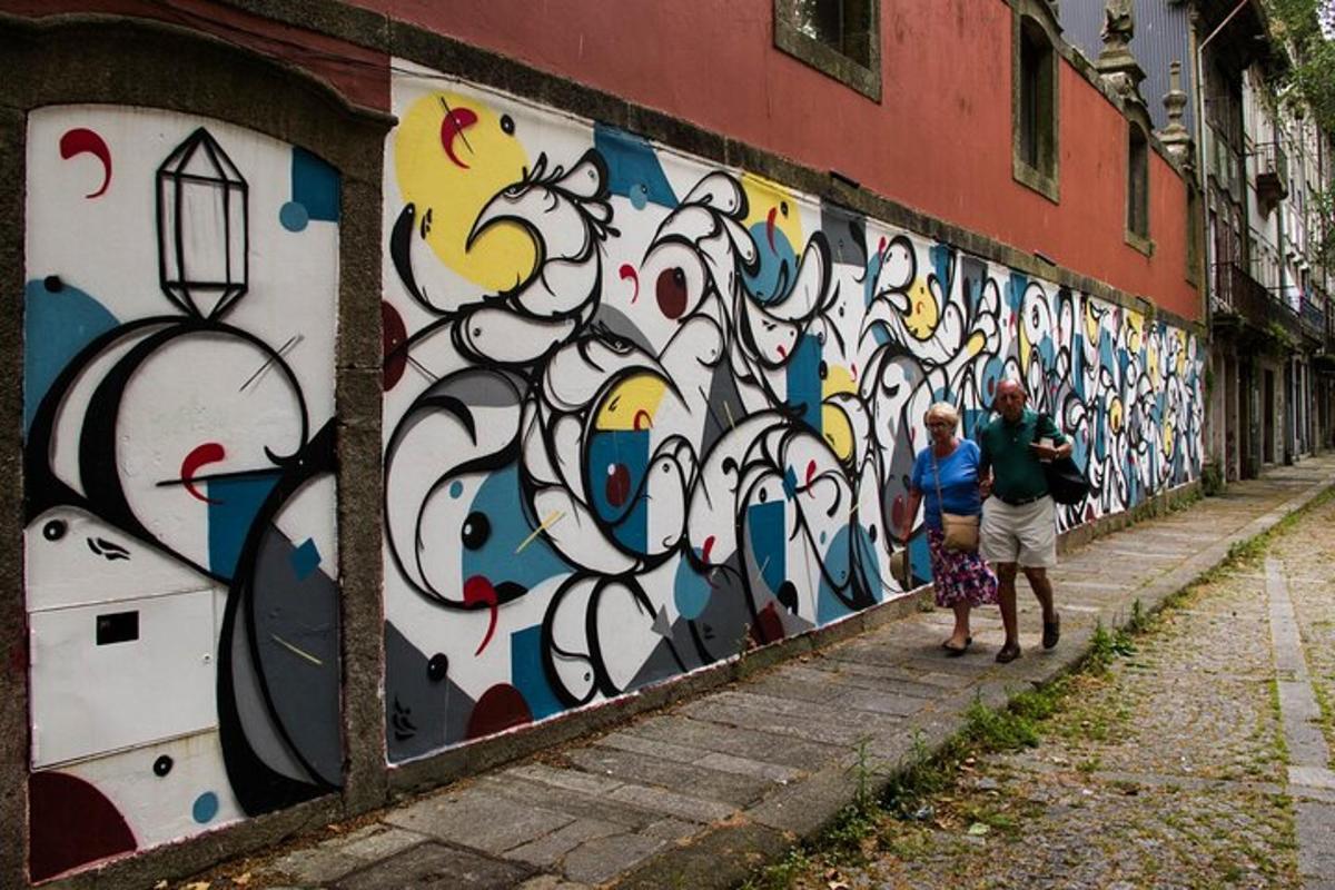 dwie osoby stojące przed ścianą pokrytą graffiti