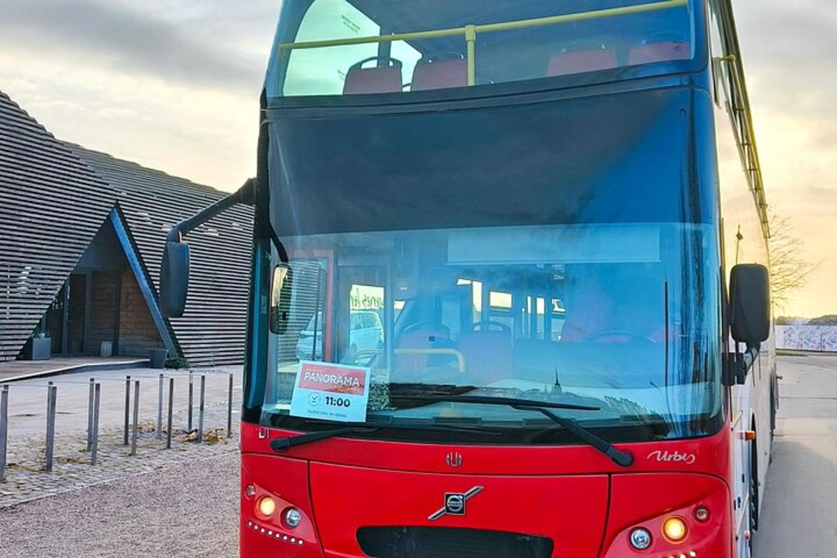 červený dvoupatrový autobus zaparkovaný vedle budovy
