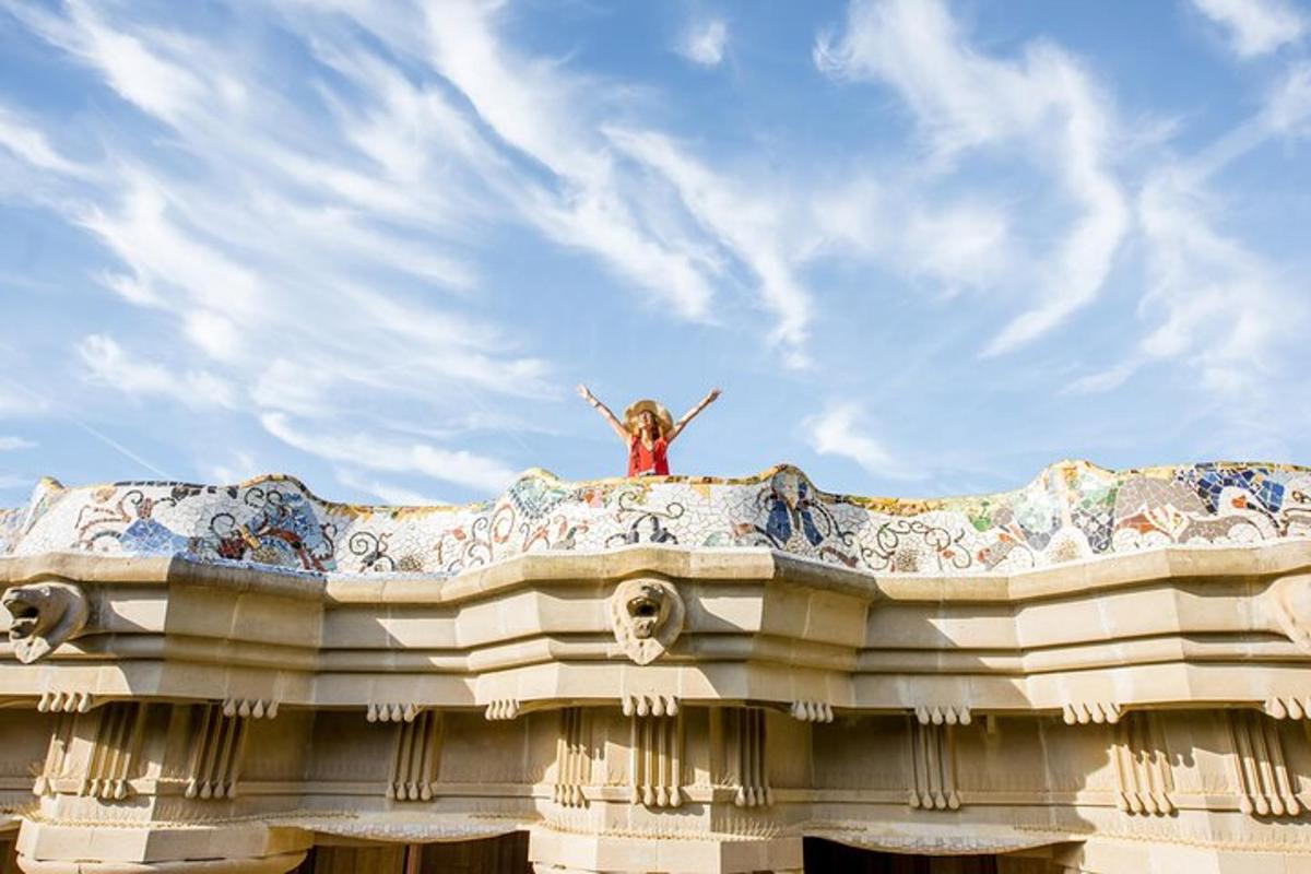 a girl sitting on top of a building with her arms up