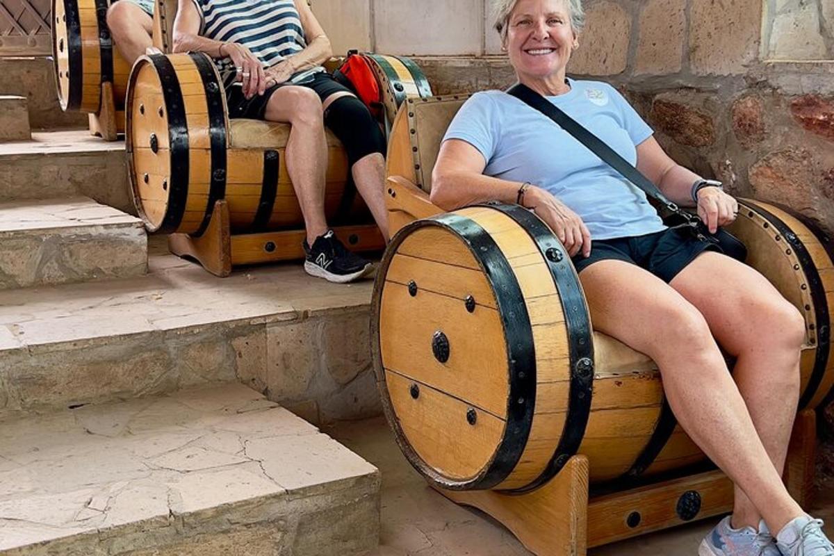 žena sedící na lavičce se sudy vína