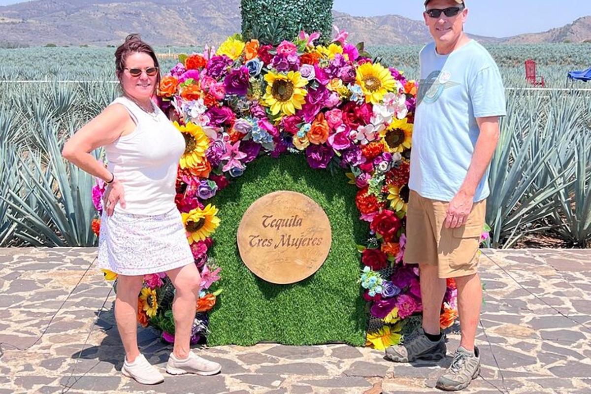 un uomo e una donna in piedi davanti a una distesa di fiori