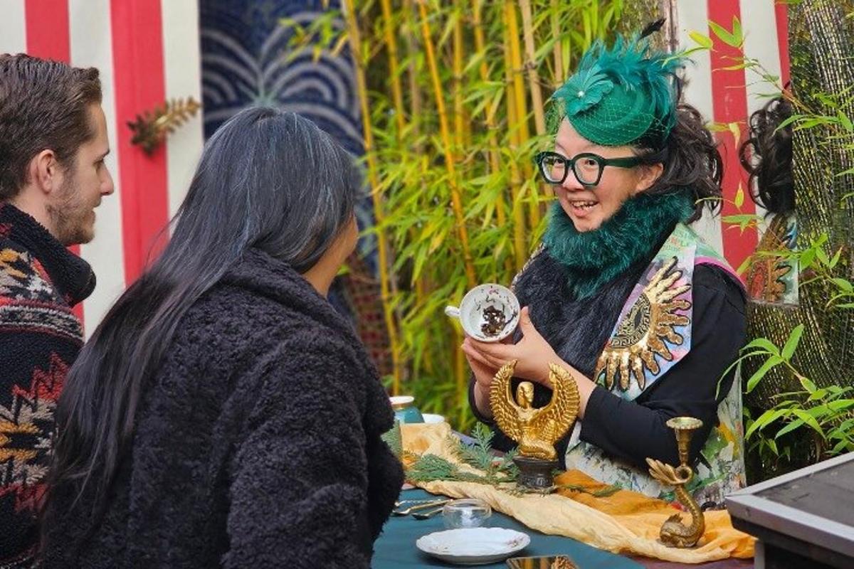 Una mujer con cabello verde y gafas hablando con otra mujer.