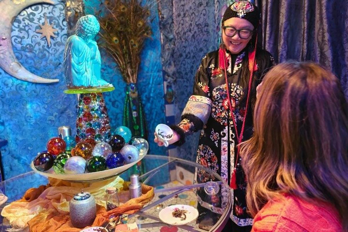 Una mujer de pie junto a una mesa con un cuenco de adornos.
