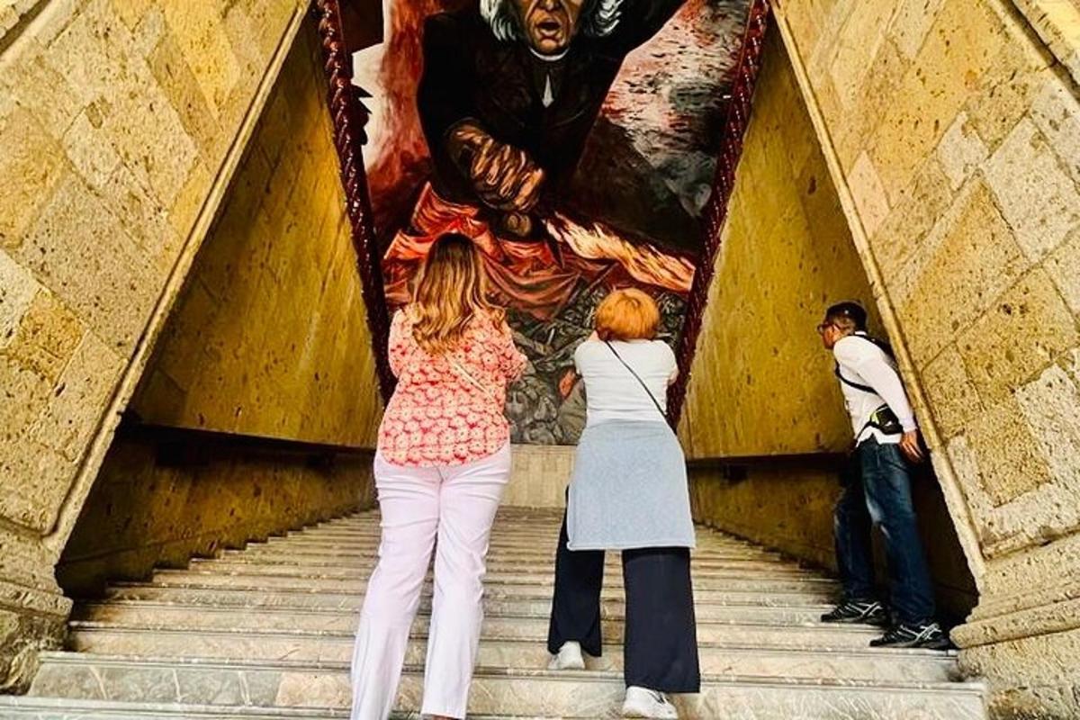 dvě ženy stojící na schodech a dívající se na obraz