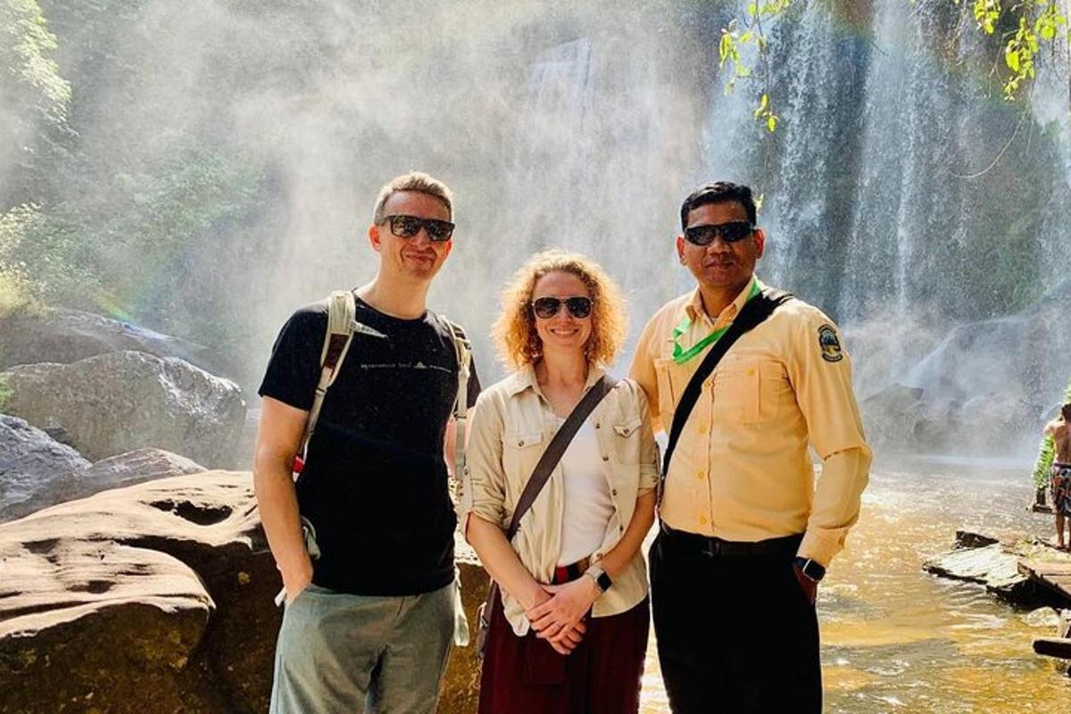 un grup de persones dempeus davant d'una cascada