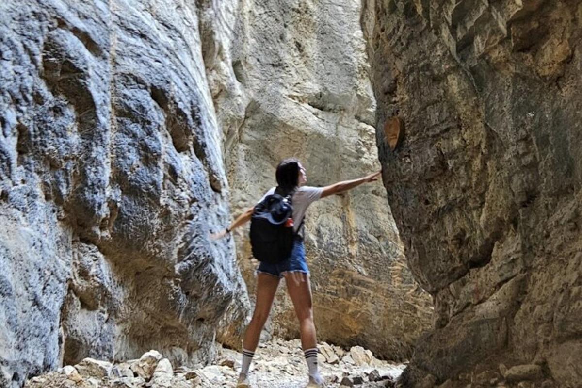 μια γυναίκα που στέκεται σε ένα φαράγγι με τα χέρια της απλωμένα