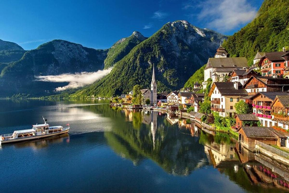 a small town on a river with mountains in the background