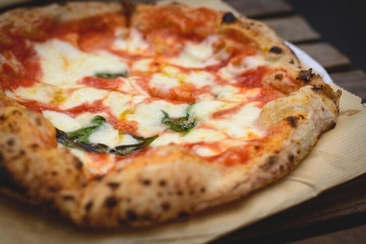 en pizza som står på toppen av et trebord