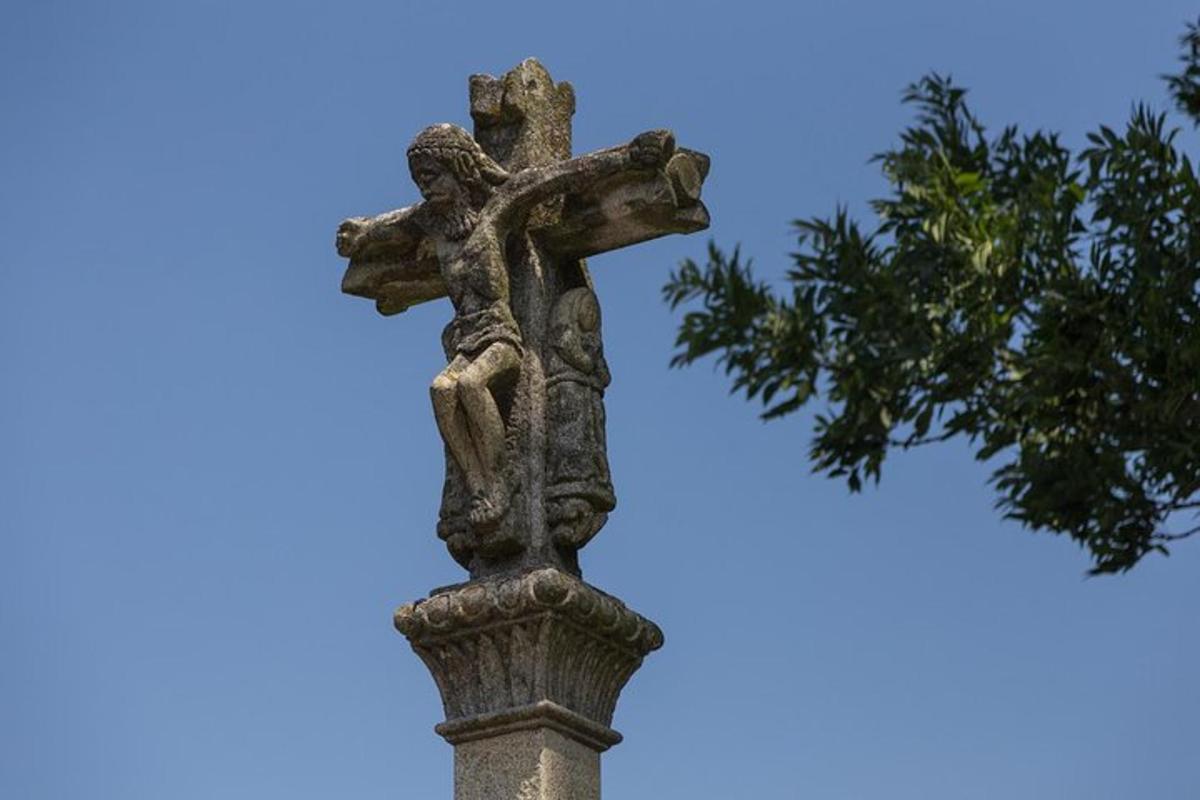 a cross on top of a pole with a tree
