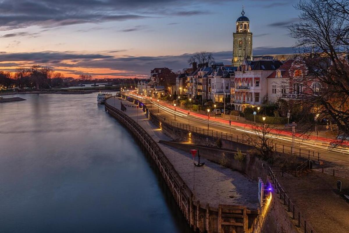 uma cidade com uma torre do relógio e um rio à noite