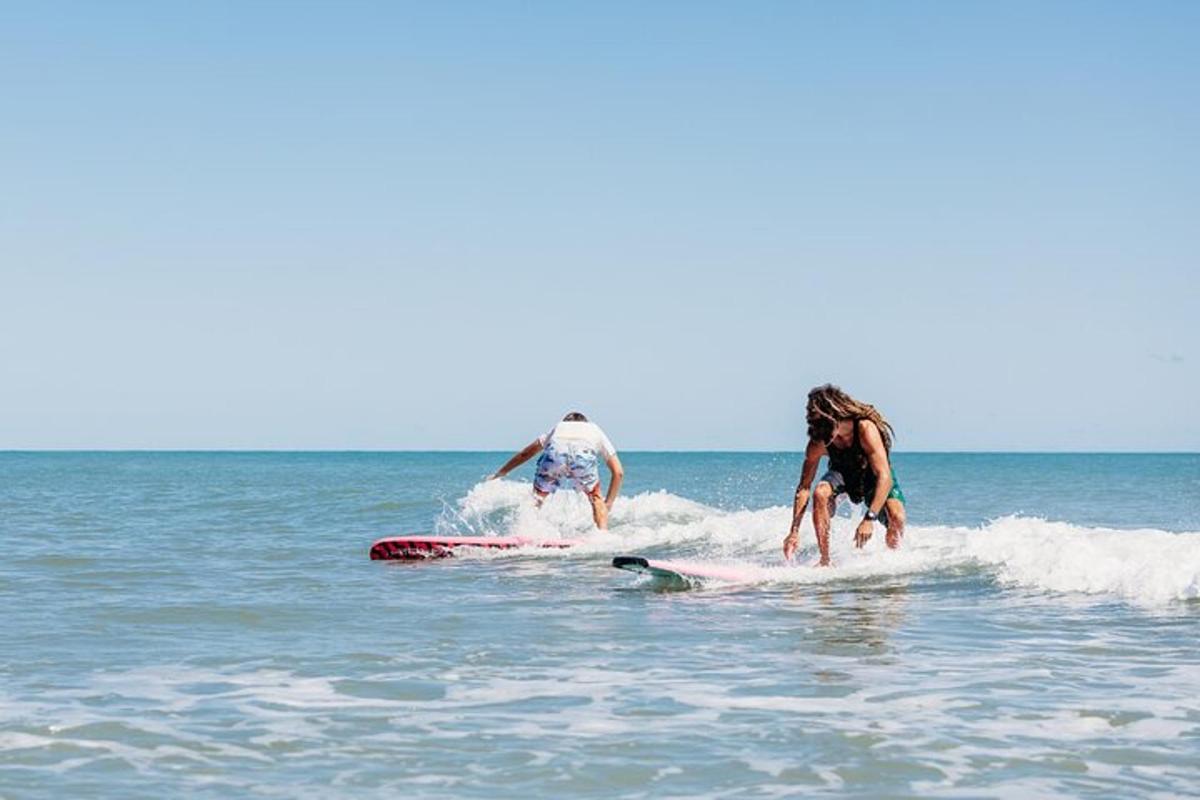to personer som rir på surfebrett i havet