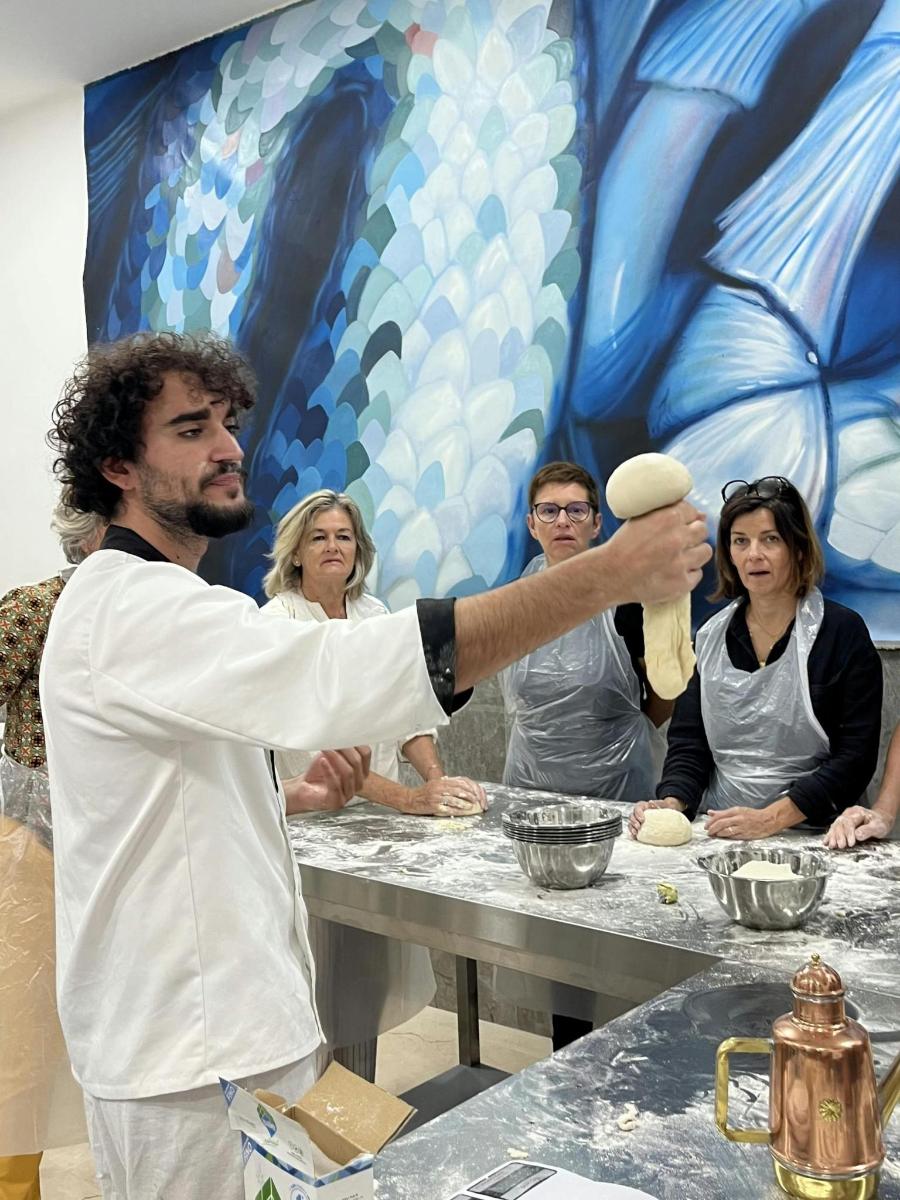 a man is holding a ball of dough at a table