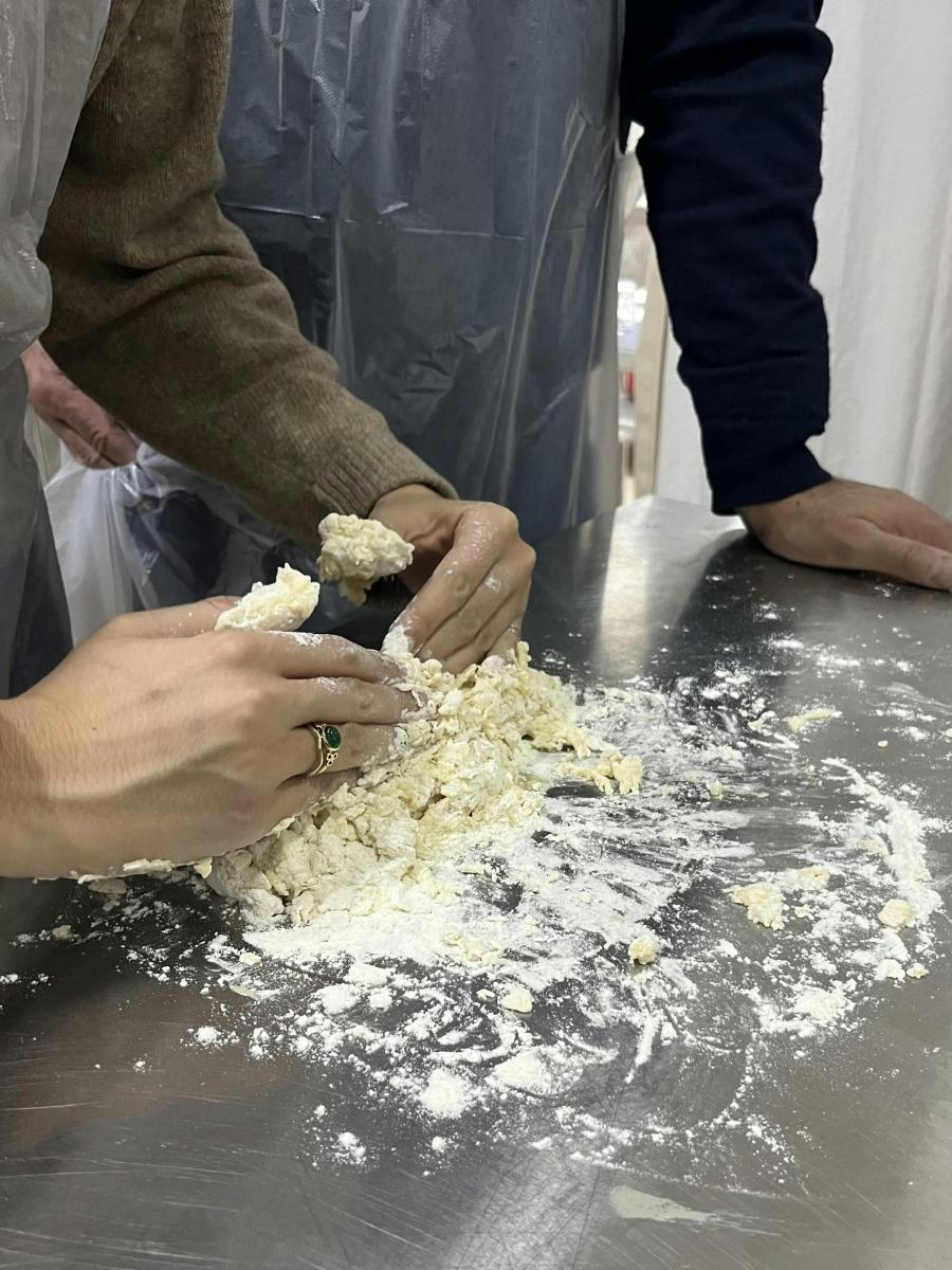dues persones estan preparant menjar a taula