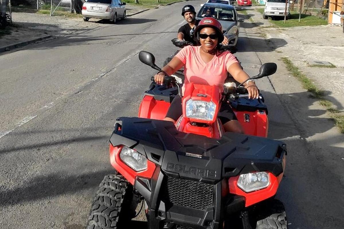 una donna che guida un quad rosso sulla strada