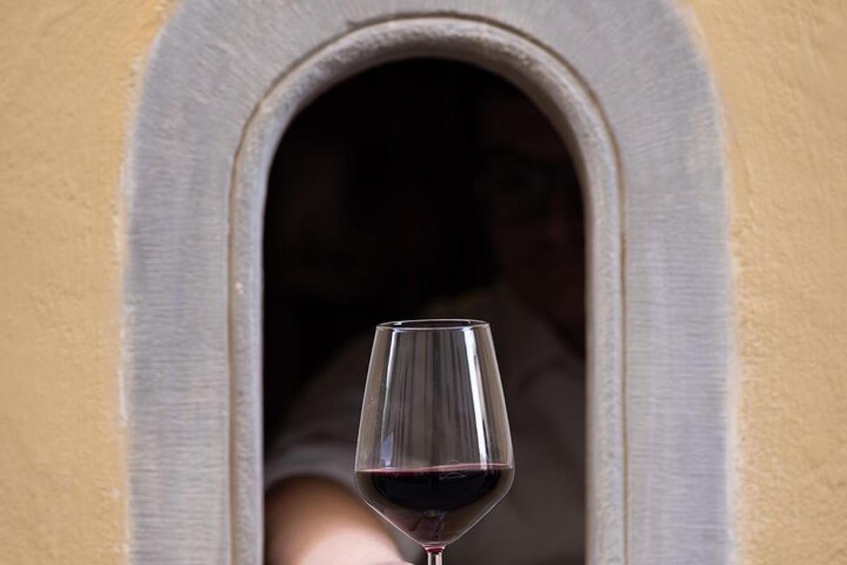 un verre de vin rouge posé devant une fenêtre