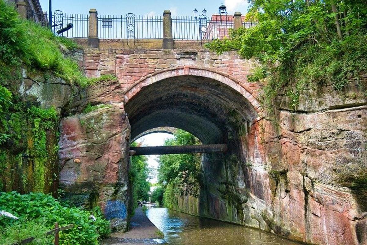 Un puente de ladrillo sobre un río con un puente sobre él