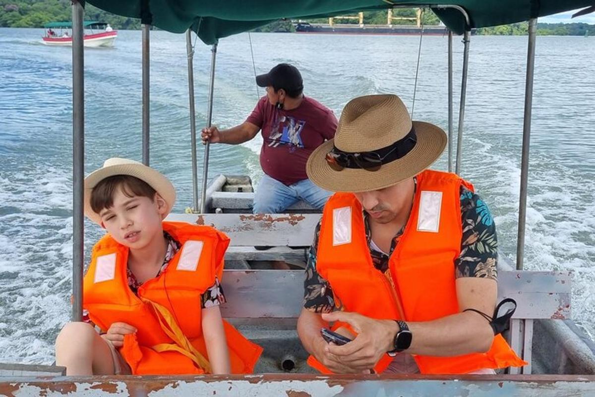 duas pessoas com coletes salva-vidas laranja sentadas em um barco