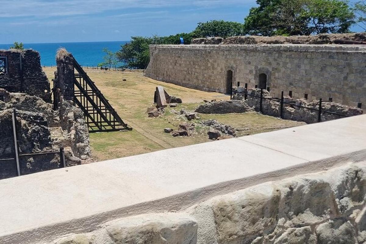 um muro de pedra com uma escada ao lado do oceano