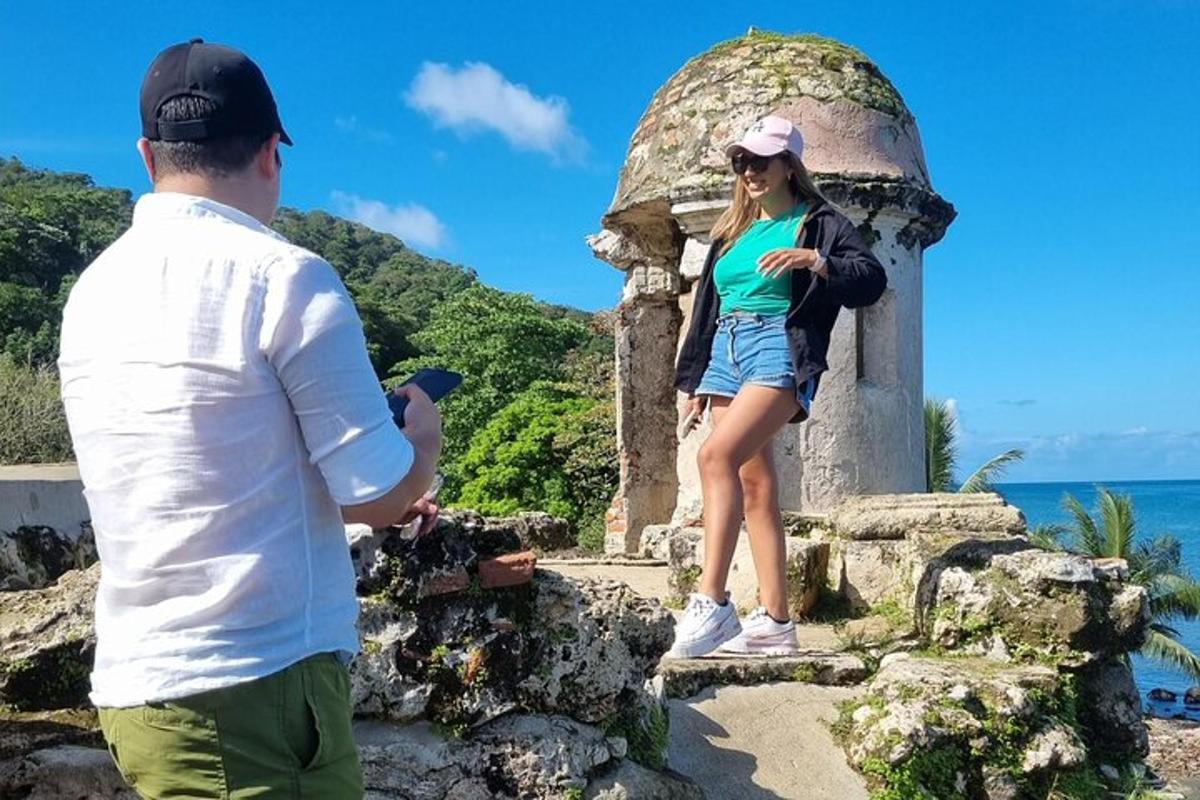 um homem tirando uma foto de uma mulher em pé em uma estátua